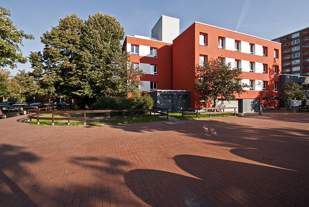 Ein Bild vom Studentenwohnheim Hannover: ein rot-weißes, quadratisches Haus mit drei Stockwerken.